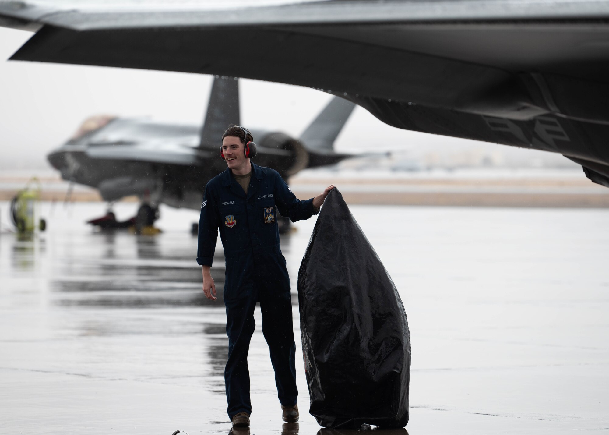 A photo of an F-35 crew chief working on a jet