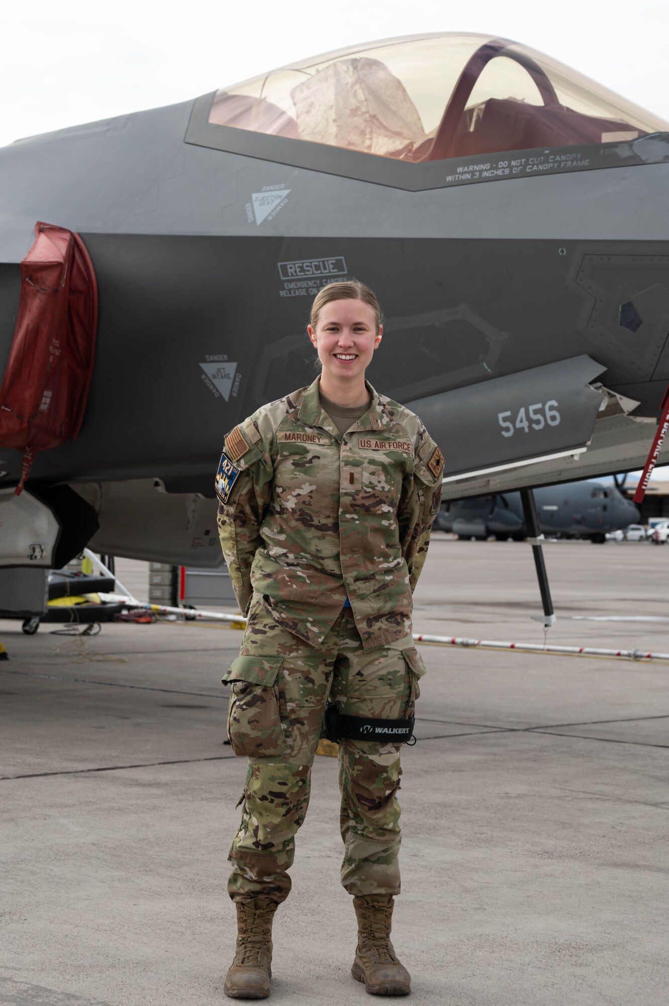 A photo of an F-35 maintainer standing in front of a jet