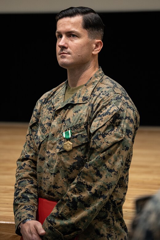 U.S. Marines Corps Sgt. Aidan Blansfield receives a Navy and Marine Corps Commendation Medal during a ceremony at the base theater on Camp Schwab, Okinawa, Japan, Jan. 12, 2024. The ceremony was held to award Sgt. Aidan Blansfield and Cpl. Jacob Cogswell with Navy and Marine Corps Commendation Medals for life saving acts while on pre-deployment leave. Both Marines awarded rescued a civilian from drowning. Blansfield, a native of Rhode Island, is a machine gunner with 2d Battalion, 2d Marine Regiment. 2/2 is currently forward deployed in the Indo-Pacific under 4th Marine Regiment, 3d Marine Division as part of the Unit Deployment Program. (U.S. Marine Corps photo by Cpl. Eduardo Delatorre)