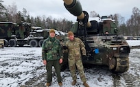 Raphael Scharf, a support operations transportation specialist at Army Field Support Battalion-Germany, (left) poses for a photo with a Soldier in front of an M109 Paladin self-propelled howitzer from the Army Prepositioned Stocks-2 worksite in Mannheim, Germany. Scharf, who is a certified social worker and did his university thesis on how stress effects Soldiers, said the Army must focus on both its people and its mission to be successful. (U.S. Army courtesy photo)