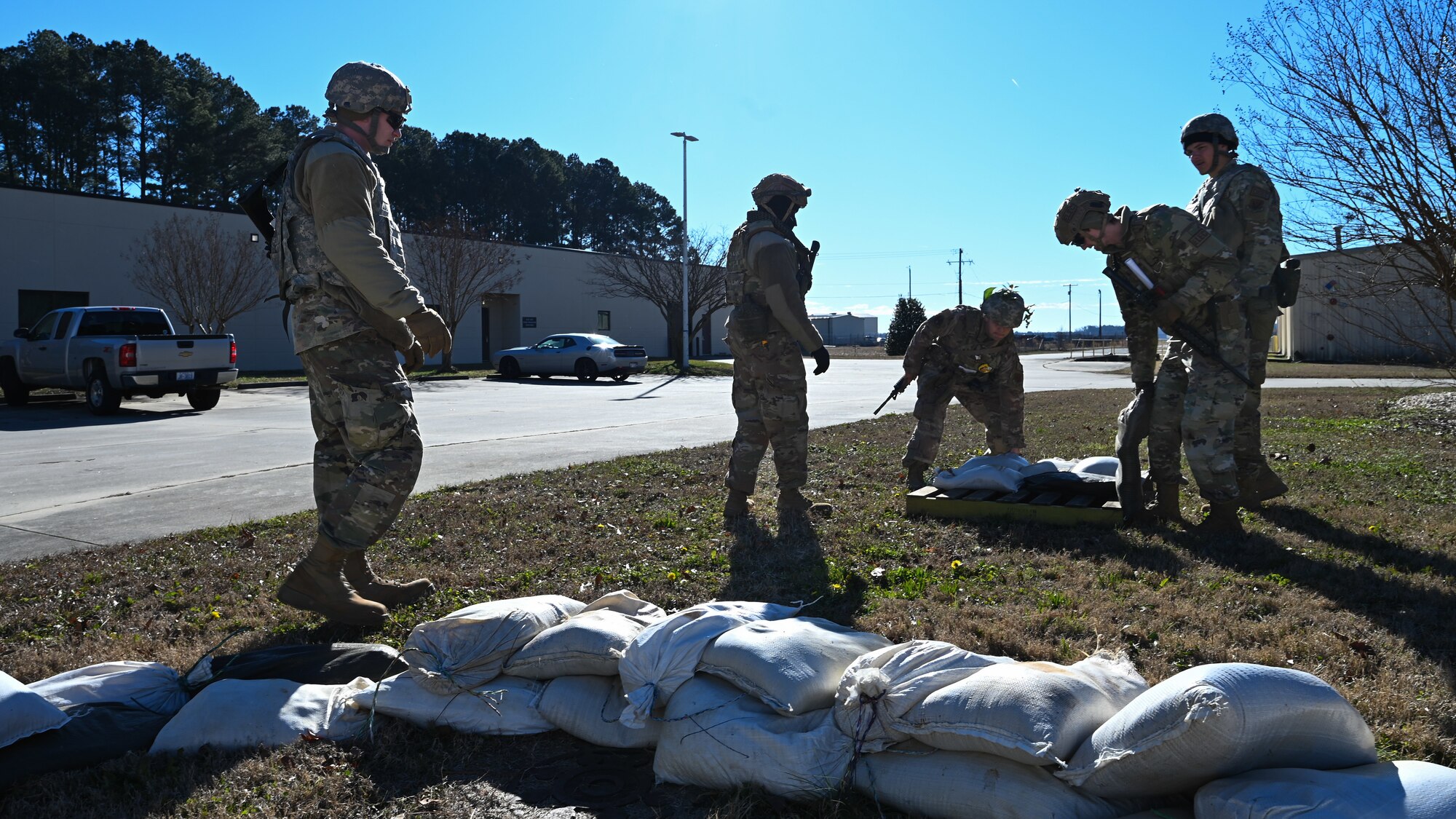 U.S. Airmen assigned to the 4th Civil Engineer Squadron fill sandbags during  a bivouac training exercise at Seymour Johnson Air Force Base, North Carolina, Jan. 18, 2024. Over the course of the exercise, participants practiced building defensive fighting positions, responded to vehicle checkpoints and performed post-attack reconnaissance sweeps , while demonstrating their ability to survive and operate in a hostile environment. (U.S. Air Force Photo by Airman Rebecca Tierney)