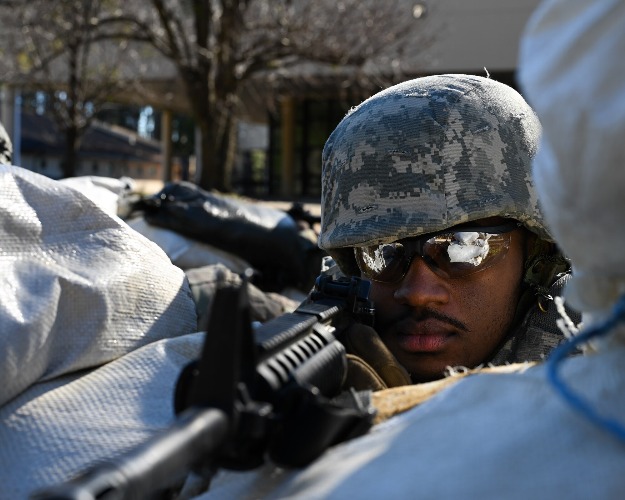 U.S. Airman 1st Class Gregory Curry, an electrical systems apprentice assigned to the 4th Civil Engineer Squadron, defends his position during a bivouac training exercise at Seymour Johnson Air Force Base, North Carolina, Jan. 18, 2024. Over the course of the exercise, participants practiced building defensive fighting positions, responded to vehicle checkpoints, and performed post-attack reconnaissance sweeps , while demonstrating their ability to survive and operate in a hostile environment. (U.S. Air Force Photo by Airman Rebecca Tierney)