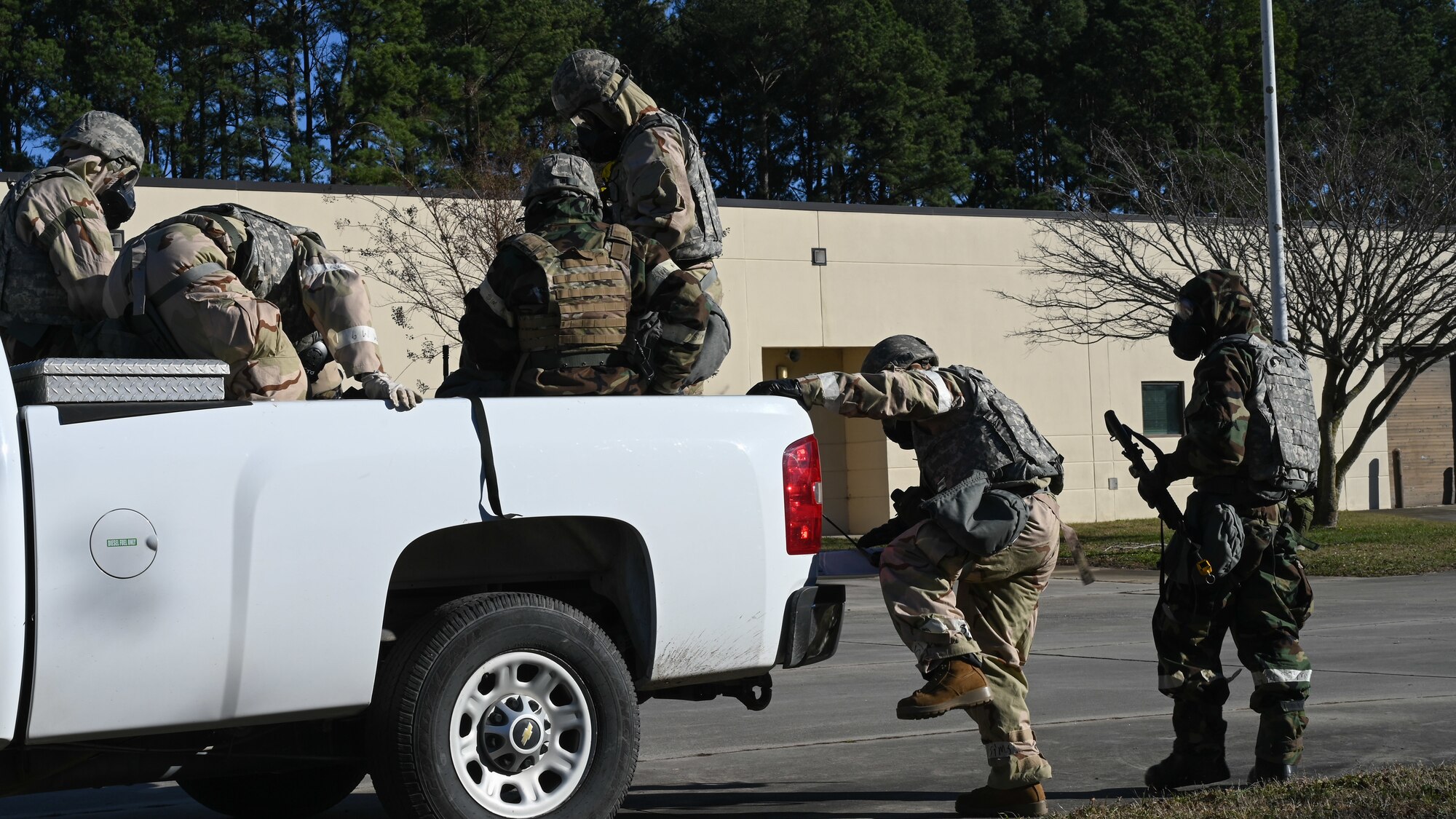 U.S. Airmen assigned to the 4th Civil Engineer Squadron climb into the back of a vehicle during a bivouac training exercise at Seymour Johnson Air Force Base, North Carolina, Jan. 18, 2024. The bivouac training tested the squadron's ability to secure and establish base operations infrastructure within a timely manner and conduct contingency and wartime operations if the opportunity were to arise. (U.S. Air Force Photo by Airman Rebecca Tierney)