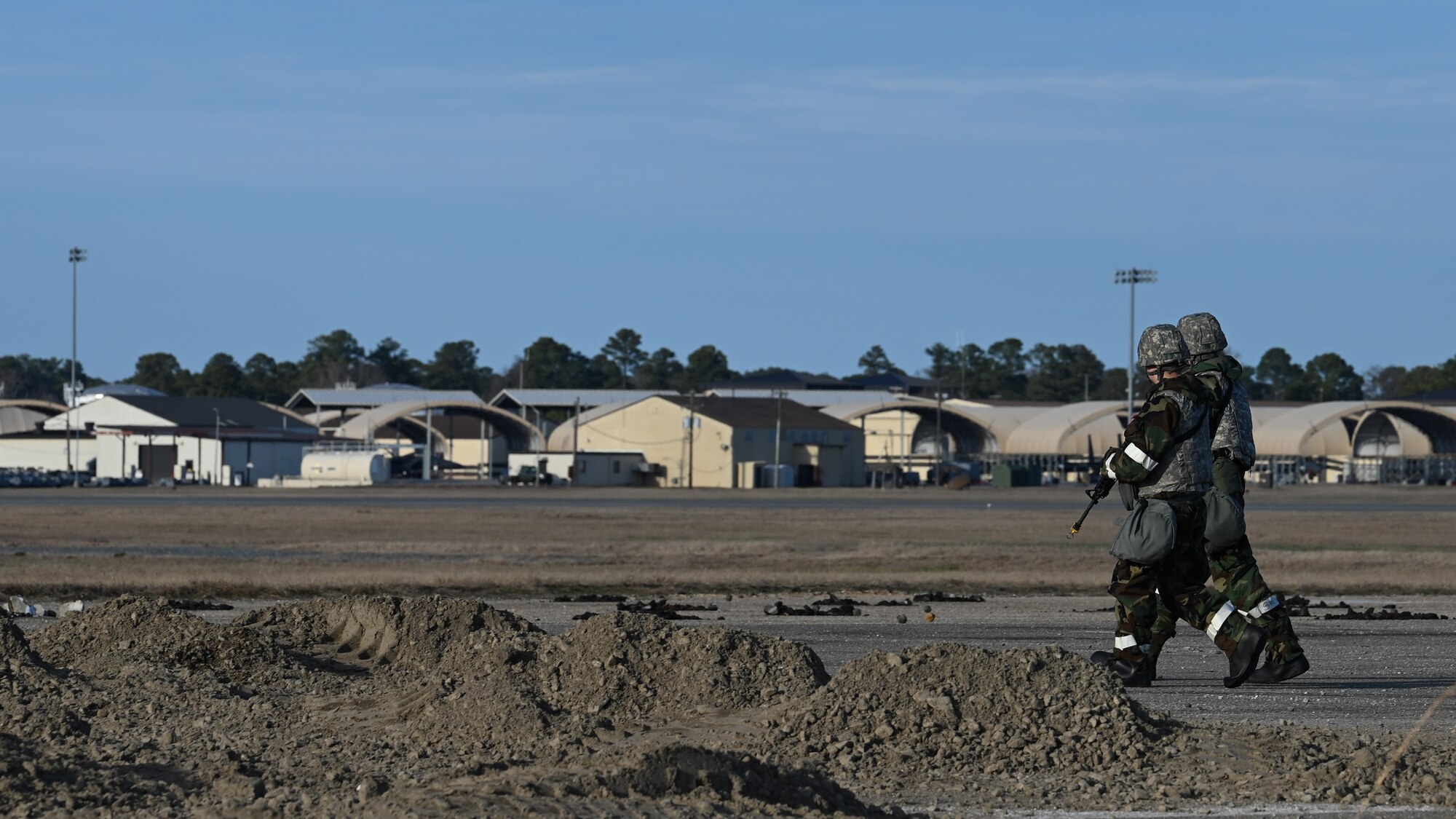 U.S. Airmen assigned to the 4th Civil Engineer Squadron are issued weapons for a bivouac field training exercise at Seymour Johnson Air Force Base, North Carolina, Jan. 18, 2024. Over the course of the exercise, participants practiced building defensive fighting positions, responded to vehicle checkpoints and performed post-attack reconnaissance sweeps, while demonstrating their ability to survive and operate in a hostile environment. (U.S. Air Force Photo by Airman Rebecca Tierney)