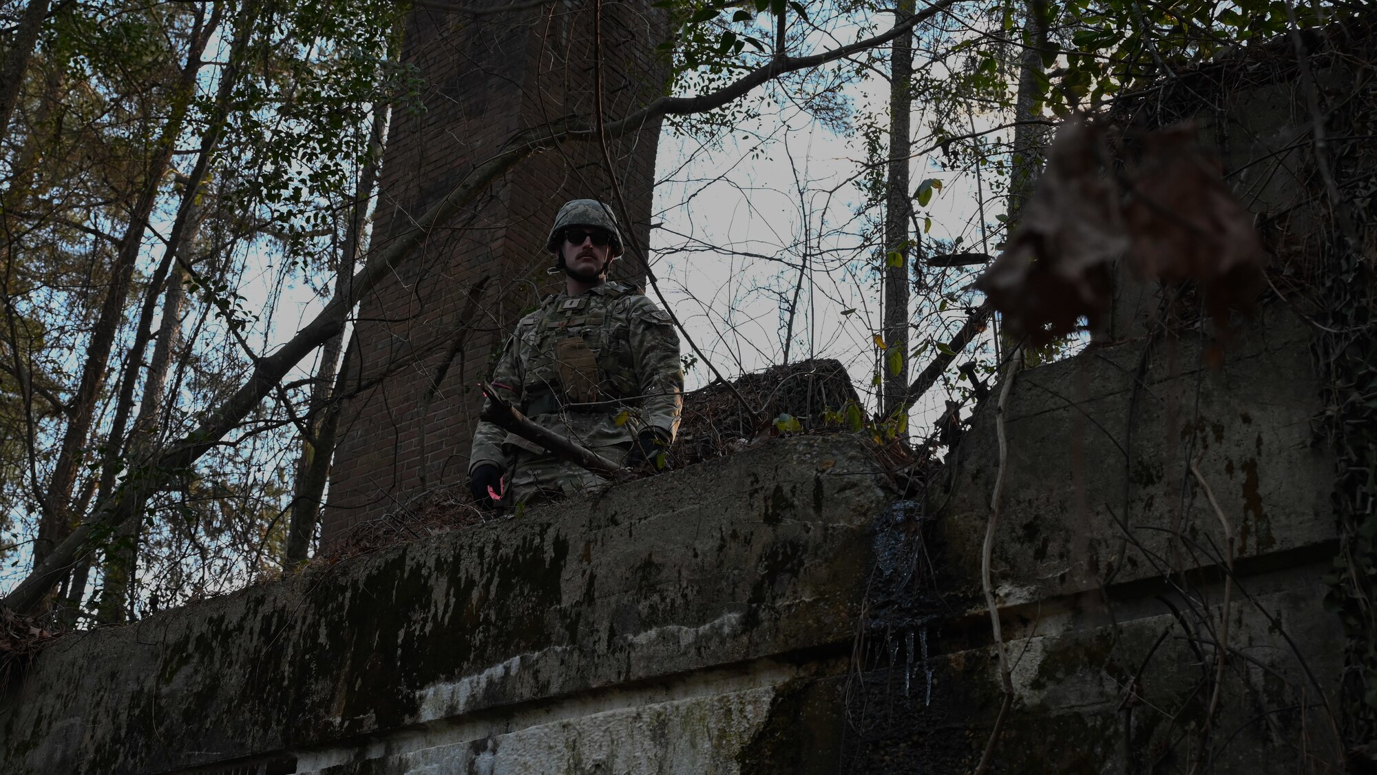 U.S. Air Force 2nd Lt. Spencer Miller, Officer In Charge of Requirement and Optimization at the 4th Civil Engineer Squadron, stands on a building during a bivouac field training exercise at Seymour Johnson Air Force Base, North Carolina, Jan. 18, 2024. Over the course of the exercise, participants practiced building defensive fighting positions, responded to vehicle checkpoints, and performed post-attack reconnaissance sweeps , while demonstrating their ability to survive and operate in a hostile environment.