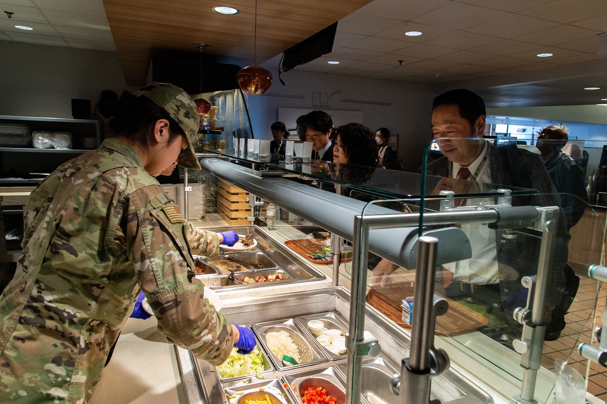 Members of the Miyagi Prefecture delegation from Japan, go through the serving line at the Dining Facility at Dover Air Force Base, Delaware, Jan. 23, 2024. The delegation met with 436th Airlift Wing leadership to embody the growing bond between the “sister cities.” (U.S. Air Force photo by Roland Balik)
