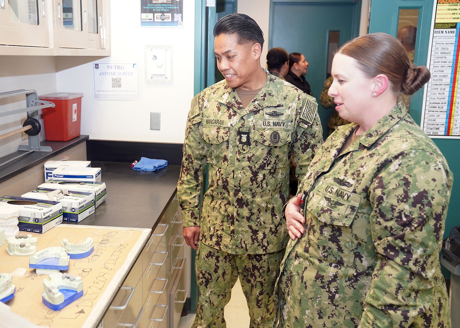 JOINT BASE SAN ANTONIO-FORT SAM HOUSTON – (Jan. 24, 2024) – Hospital Corpsman 2nd Class Amber Rimes, of Dubuque, Iowa, a dental laboratory instructor assigned to Navy Medicine Training Support Center (NMTSC), gives a tour of facilities at the Defense Health Agency’s (DHA) Medical Training and Education Campus (METC) to Force Master Chief PatrickPaul Mangaran, director, Hospital Corps, U.S. Navy Bureau of Medicine and Surgery (BUMED). METC is a leader in military medical education with over 48 academic programs in various medical specialties. With 48 medical programs, and 16,500 graduates a year, METC is a state-of-the-art Department of Defense (DoD) healthcare education campus that trains enlisted medical personnel. (U.S. Navy photo by Burrell Parmer, NMFSC Public Affairs/Released)