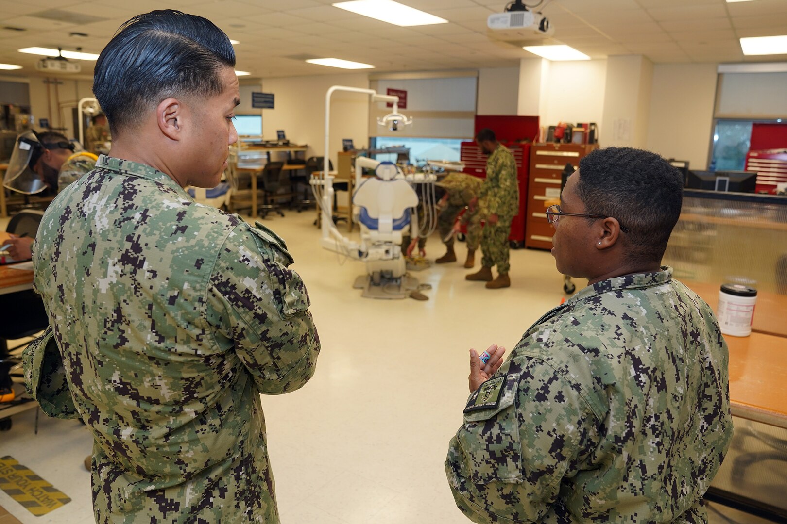 JOINT BASE SAN ANTONIO-FORT SAM HOUSTON – (Jan. 24, 2024) – Chief Hospital Corpsman Lika Brooks, of Honolulu, a biomedical instructor assigned to Navy Medicine Training Support Center (NMTSC), gives a tour of facilities at the Defense Health Agency’s (DHA) Medical Training and Education Campus (METC) to Force Master Chief PatrickPaul Mangaran, director, Hospital Corps, U.S. Navy Bureau of Medicine and Surgery (BUMED). METC is a leader in military medical education with over 48 academic programs in various medical specialties. With 48 medical programs, and 16,500 graduates a year, METC is a state-of-the-art Department of Defense (DoD) healthcare education campus that trains enlisted medical personnel. (U.S. Navy photo by Burrell Parmer, NMFSC Public Affairs/Released)
