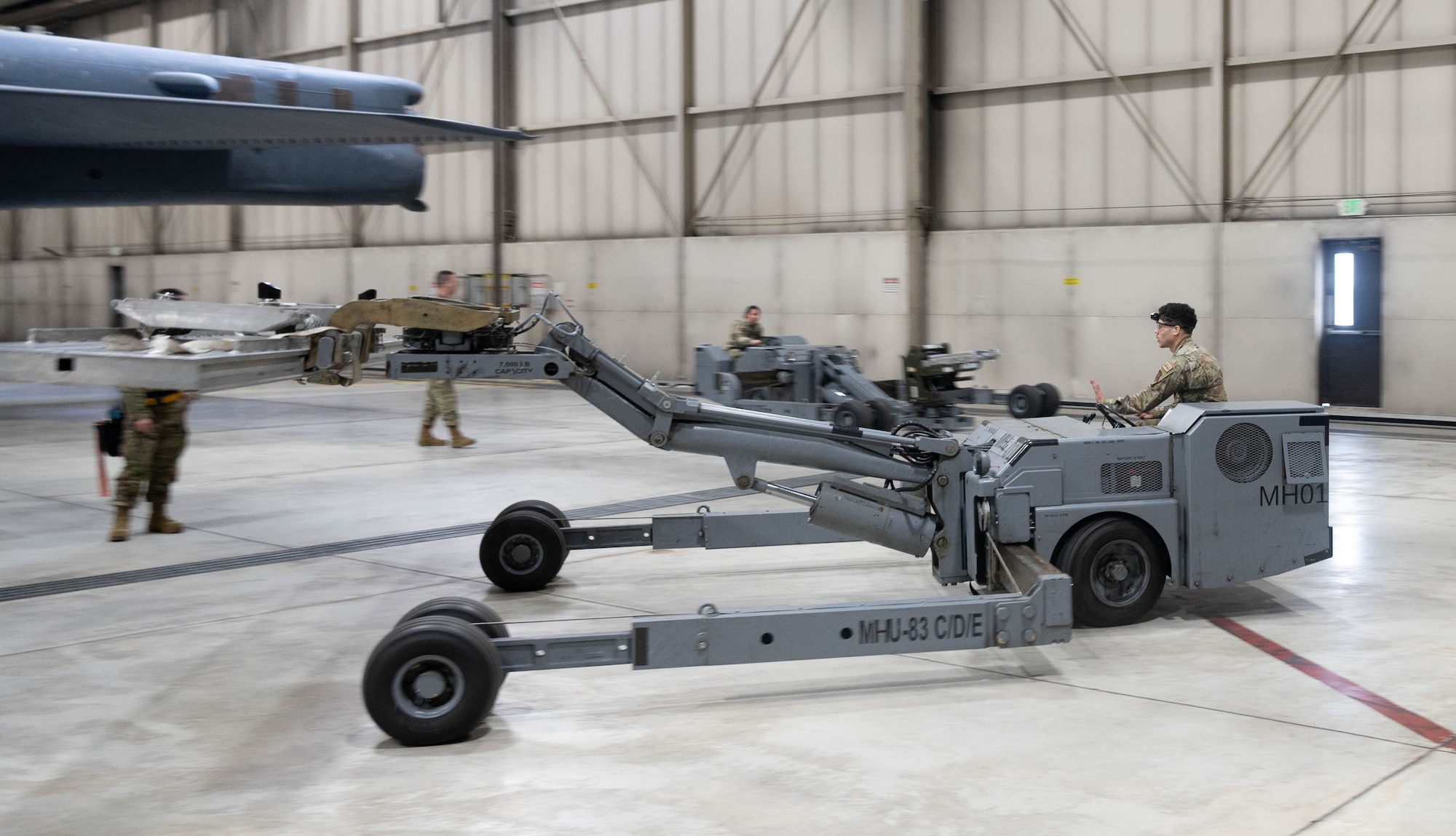 Senior Airman Benjamin Rivera, 5th Aircraft Maintenance Squadron weapons load crew member, drives a missile carrier during the 2024 annual weapons load competition at Minot Air Force Base, North Dakota, Jan. 19, 2024. This competition allowed Airmen to see how efficiently and safely they could load an inert JASSM onto a B-52H Stratofortress in a high stress environment.