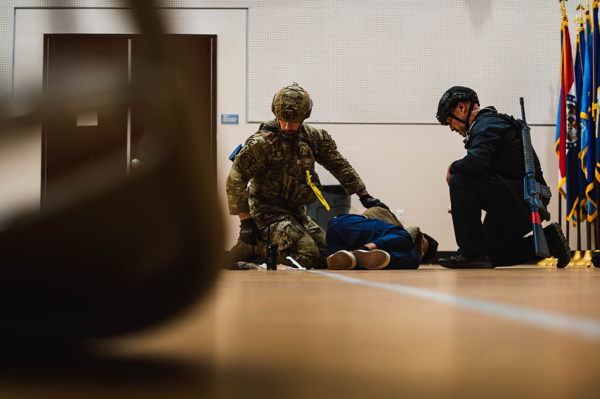 William Anderson (left), 56th Security Forces Squadron defender, and Tech Sgt. Jacob Sime (right), 56th SFS defender, perform a simulated emergency medical examination on a simulated injured victim during an active shooter exercise.