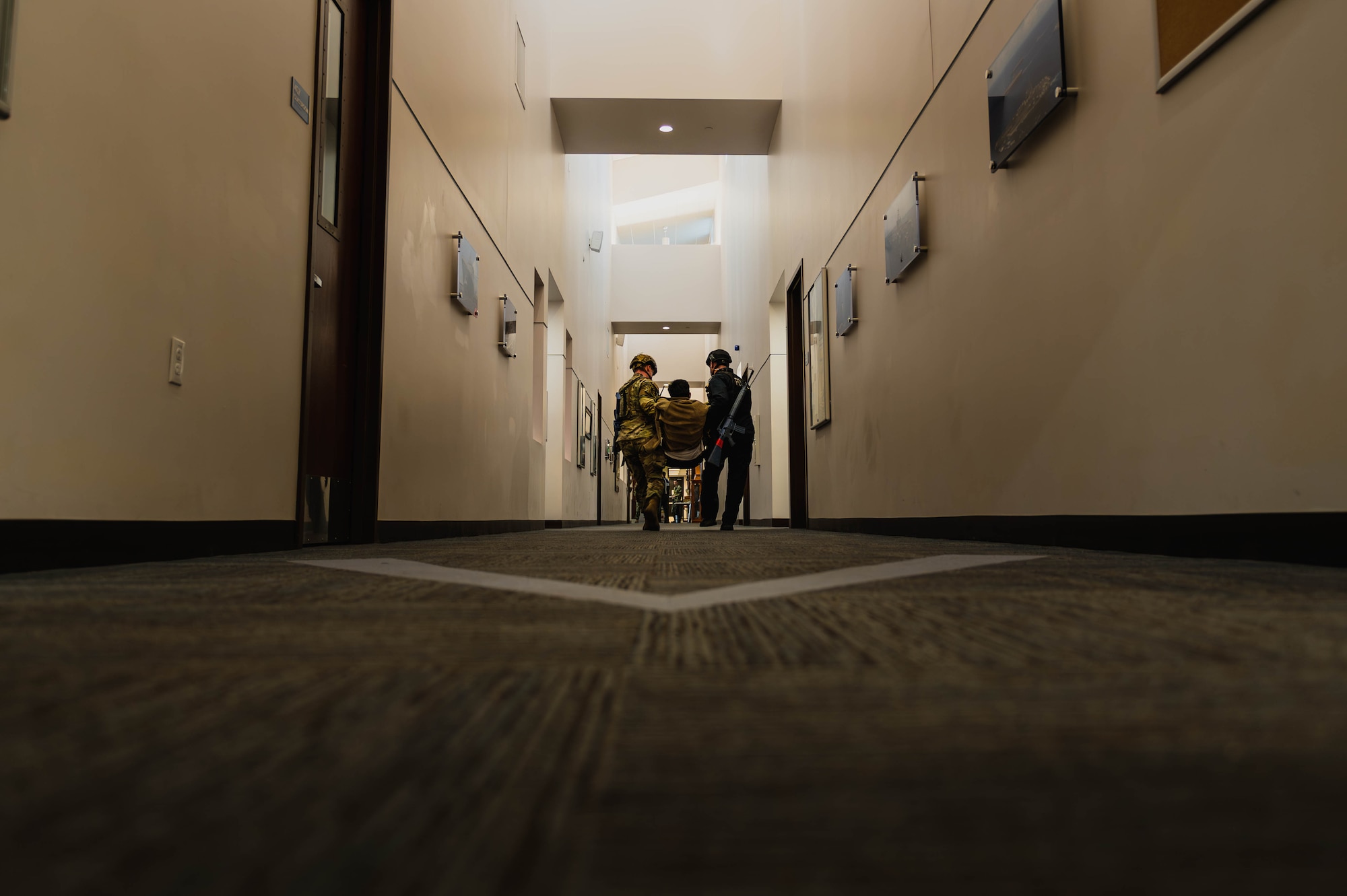 William Anderson (left), 56th Security Forces Squadron defender, and Tech Sgt. Jacob Sime (right), 56th SFS defender, perform a simulated emergency medical examination on a simulated injured victim during an active shooter exercise.