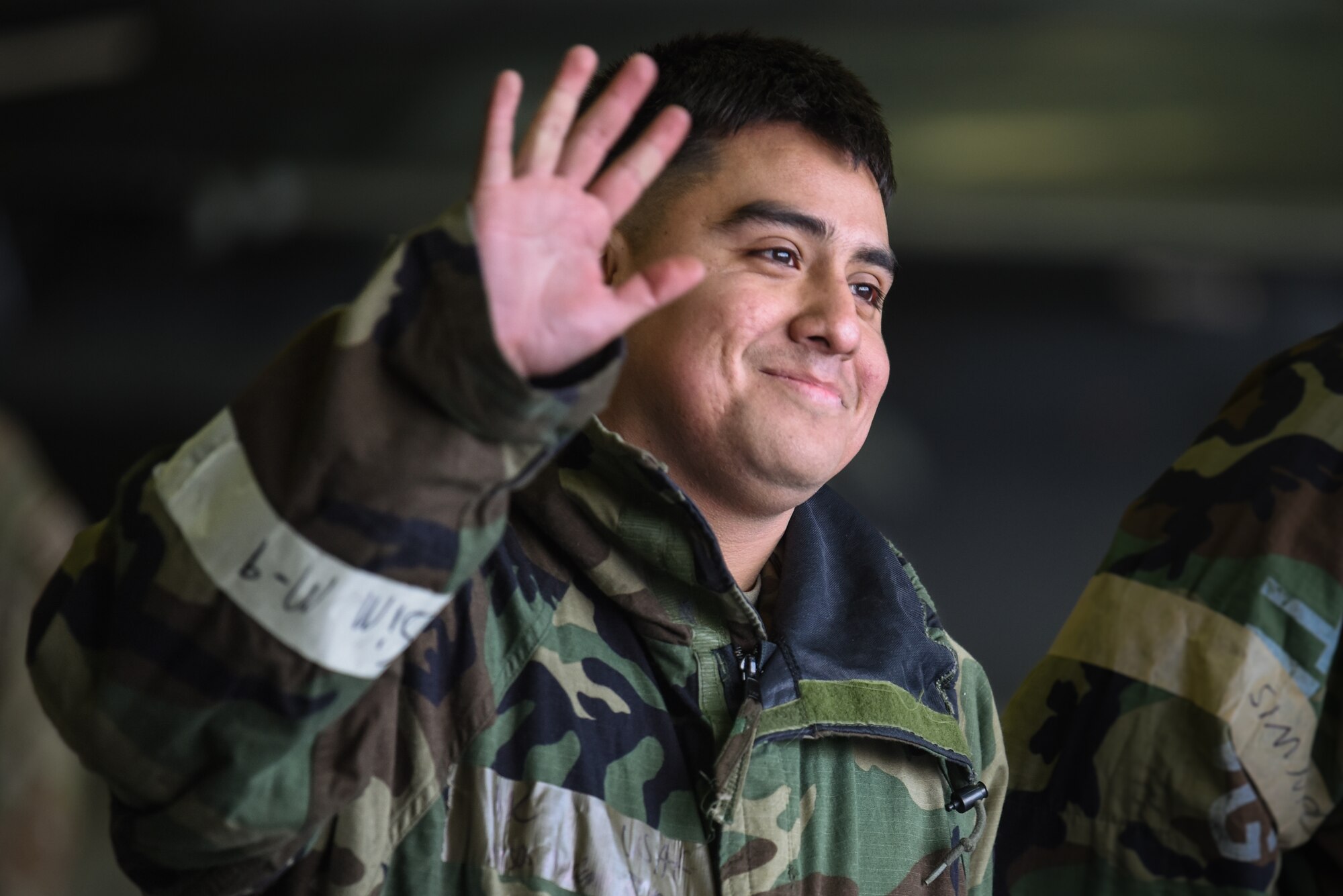U.S. Air Force Airman 1st Class Bryan Alejos Angviano, 25th Fighter Generation Squadron weapons load crew member, waves to a crowd during the annual bomb-building and weapons Load Crew Competition at Osan Air Base, Republic of Korea, Jan. 19, 2024. This friendly competition between the units cultivates a positive and motivational environment, encouraging Airmen to continually strive for excellence. A high standard of performance ensures the 51st  Fighter Wing mission is executed with precision, reliability and effectiveness. (U.S. Air Force photo by Senior Airman Brittany Russell)
