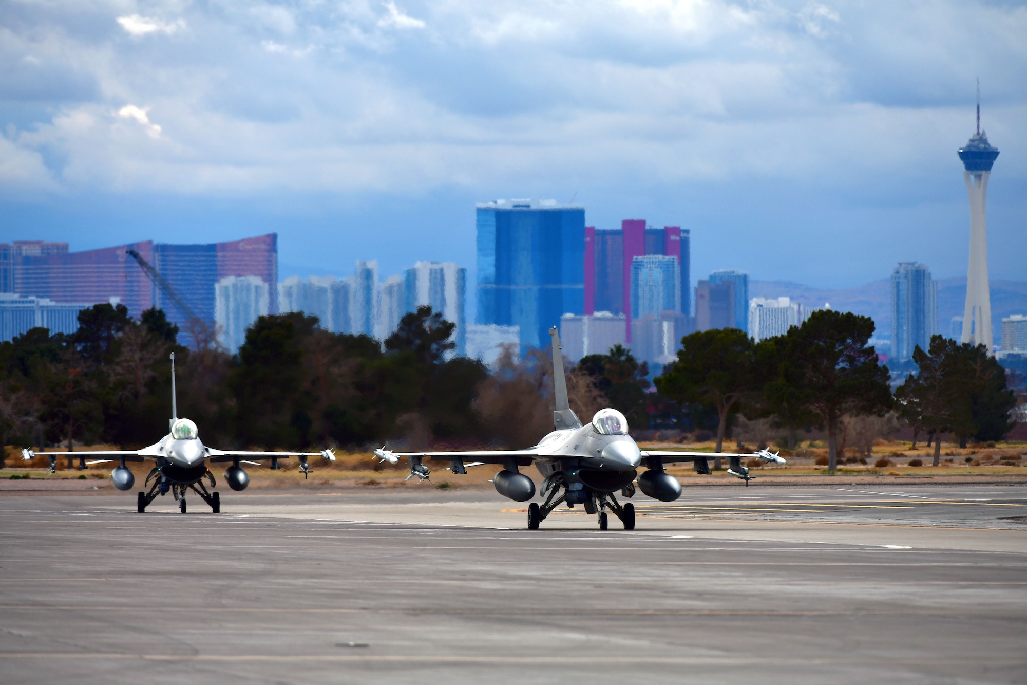 2 jets on runway with las vegas strip in background