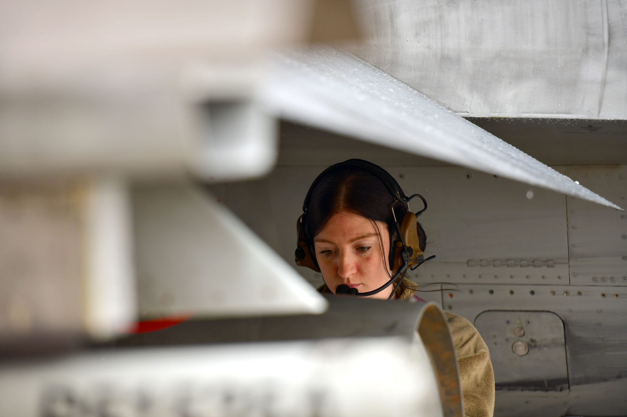 woman with headset on under a jet