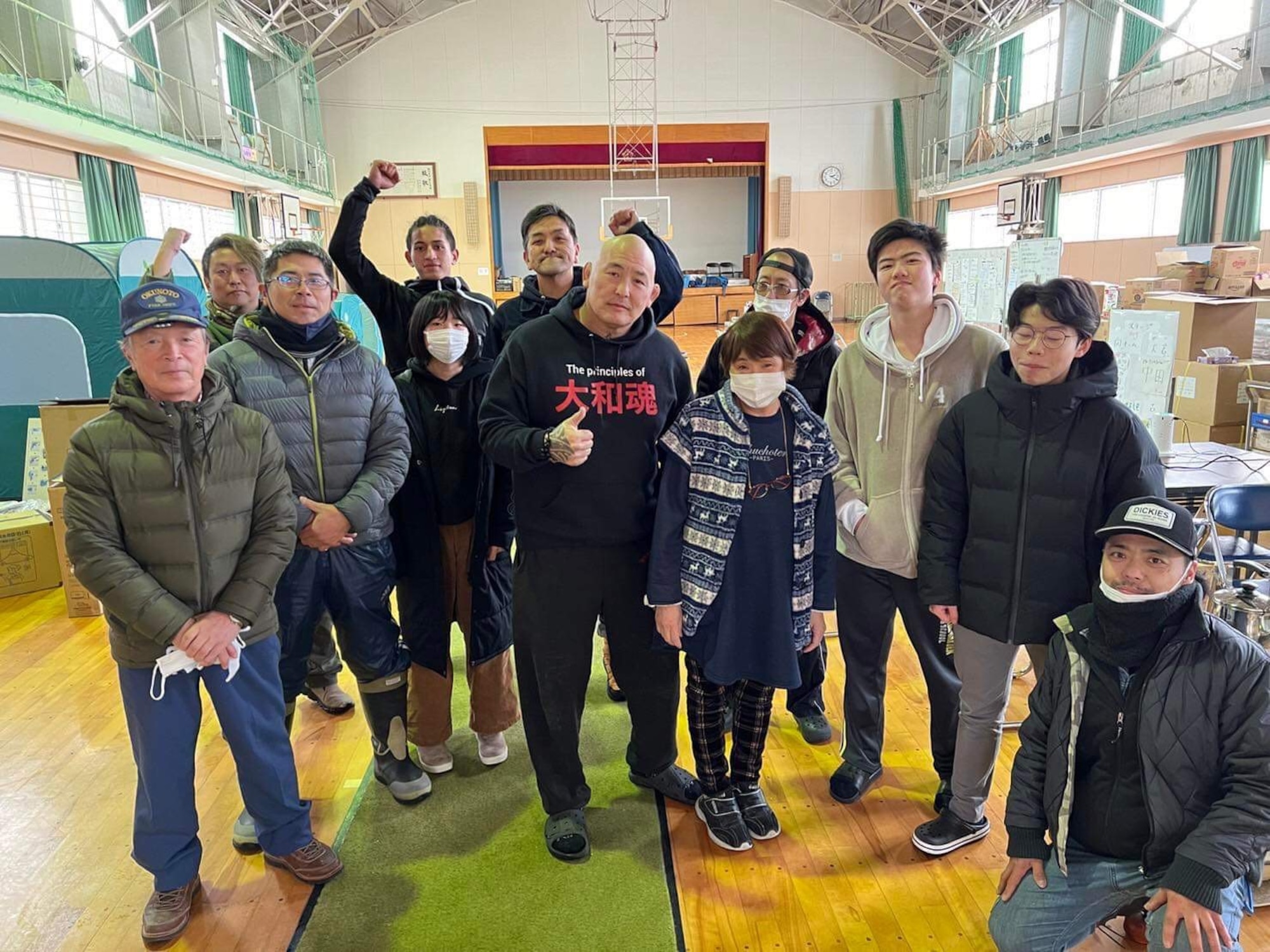 Enson Inoue poses for a photo with evacuation site volunteers.
