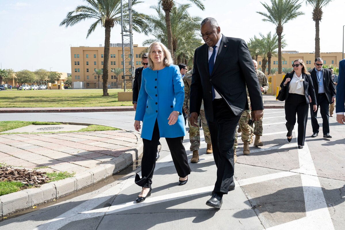Two people in civilian attire walk outdoors.