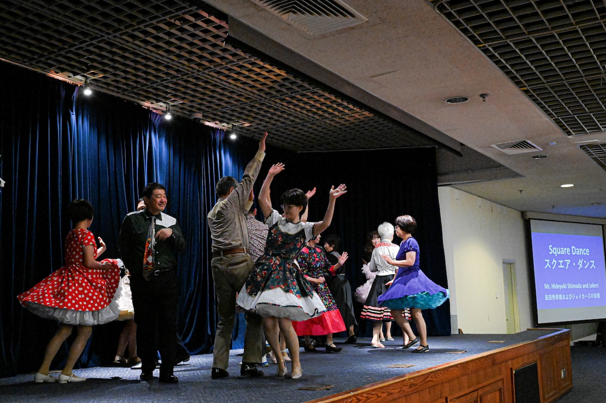 a group of people on stage dancing.