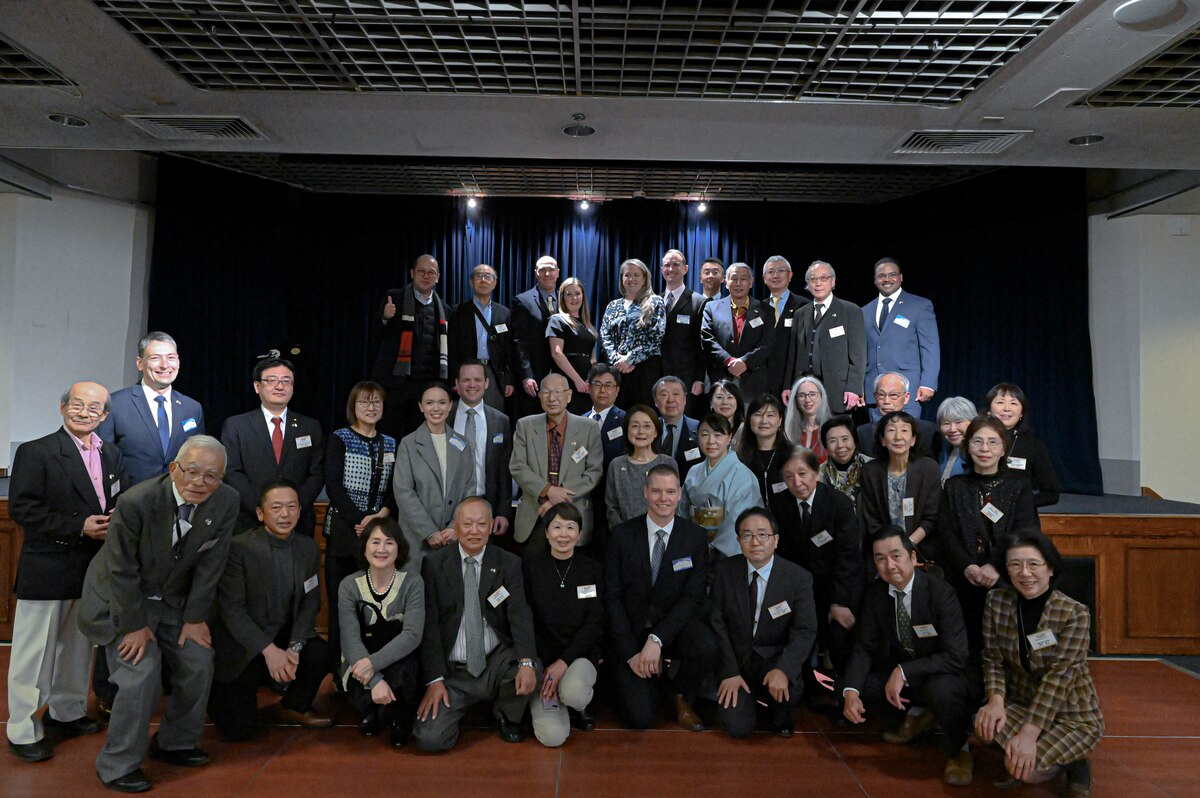 Group of people on a stage all together posing for a photo