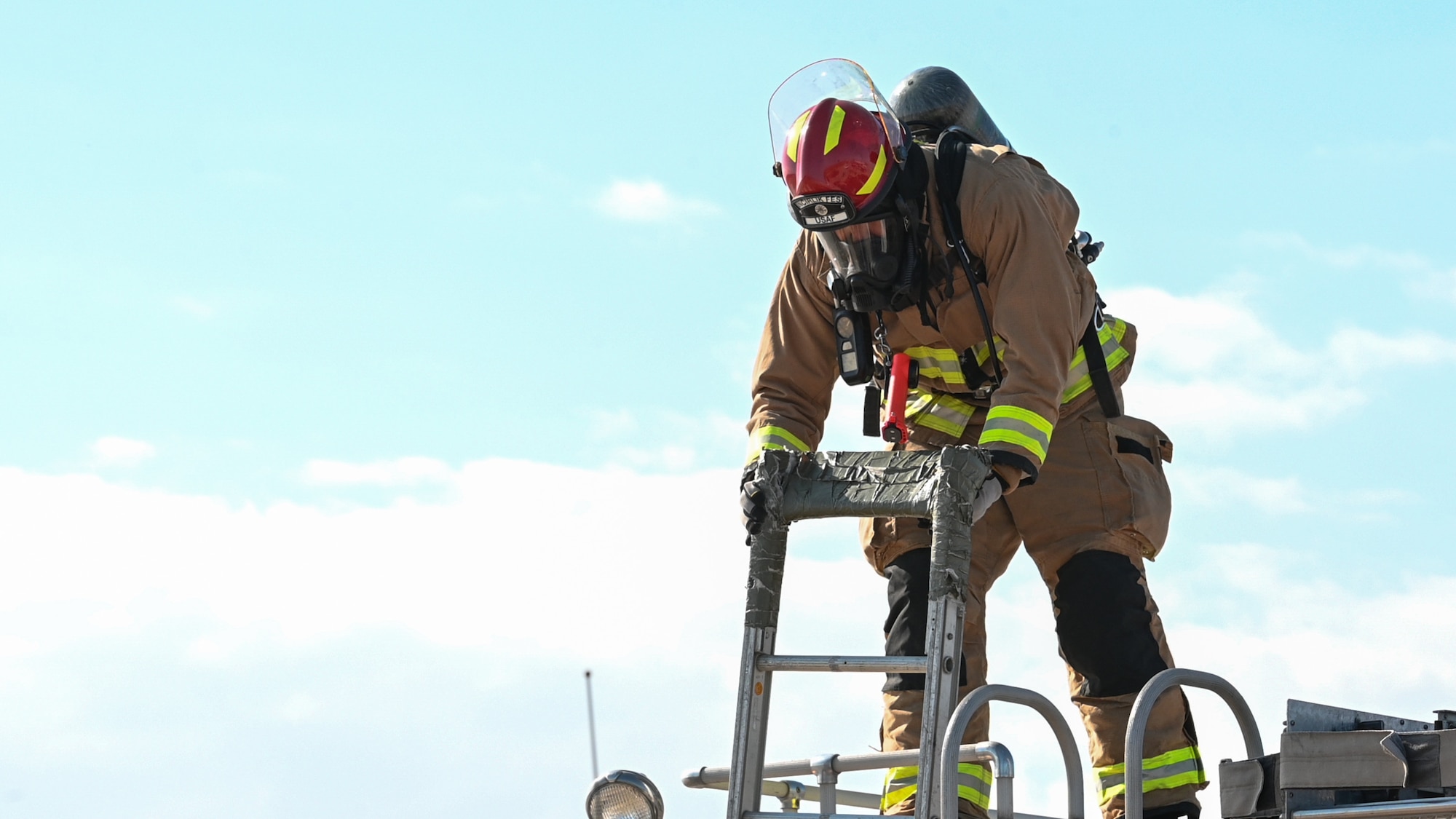 a firefighter handles a ladder
