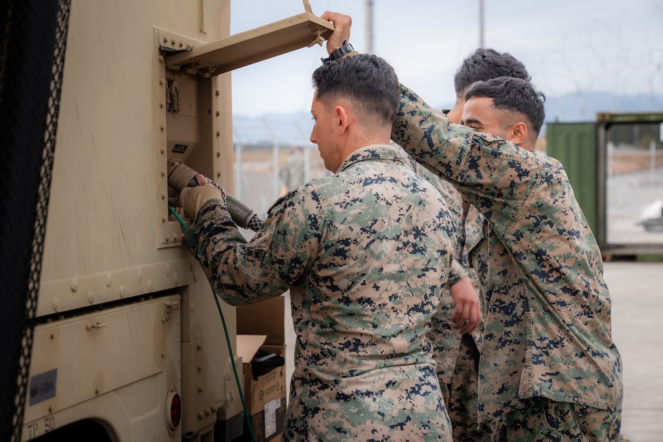 U.S. Marines with Marine Air Control Squadron (MACS) 4 connect a power cable to an AN/MRQ-13 communications system during the Nyutabaru Aviation Training Relocation at Japan Air Self-Defense Force Nyutabaru Air Base, Japan, Dec. 9, 2023. The ATR program allows U.S. aviation units in the Indo-Pacific, such as MACS-4 and Marine Aircraft Group 12, to train away from their home station to reduce local noise impacts while increasing operational readiness and interoperability. During this year’s ATR program at Nyutabaru Air Base, MAG-12 forces trained alongside the Japan Air Self-Defense Force’s 305th Tactical Fighter Squadron to build upon each other’s tactics and reinforce their combined operational readiness through safe and realistic training.