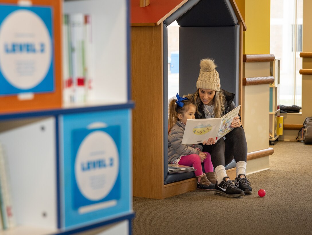 A parent reads a book to their child during the Quantico Base Library grand re-opening at the General Alfred M. Gray Marine Corps Research Center on Marine Corps Base Quantico, Virginia, Jan. 24, 2024. The library was closed for a three-month period of renovations that redesigned the library layout to be more inviting for service members and their families. (U.S. Marine Corps Photo by Lance Cpl. Kayla LeClaire)