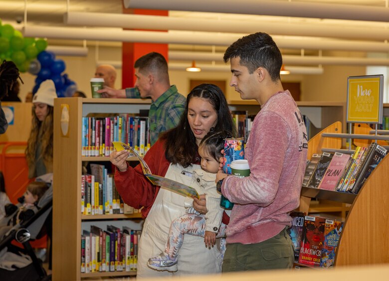 Parents read to their child during the Quantico Base Library grand re-opening at the General Alfred M. Gray Marine Corps Research Center on Marine Corps Base Quantico, Virginia, Jan. 24, 2024. The library was closed for a three-month period of renovations that redesigned the library layout to be more inviting for service members and their families. (U.S. Marine Corps Photo by Lance Cpl. Kayla LeClaire)
