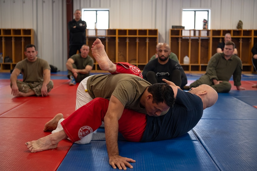 Master Carlos Machado, a Brazilian Jiu Jitsu instructor, and a member of this training team demonstrate self-defense tactics for 87th Security Forces Squadron members at Joint Base McGuire-Dix-Lakehurst, N.J., Jan. 18, 2024. Master Machado crafted BJJ instruction to expand on the hand-to-hand combat skills crucial to the Security Forces mission, merging BJJ tactics with elements of mindfulness, physical readiness, as well as honing the craft. (U.S. Air Force photo by Staff Sgt. Monica Roybal)