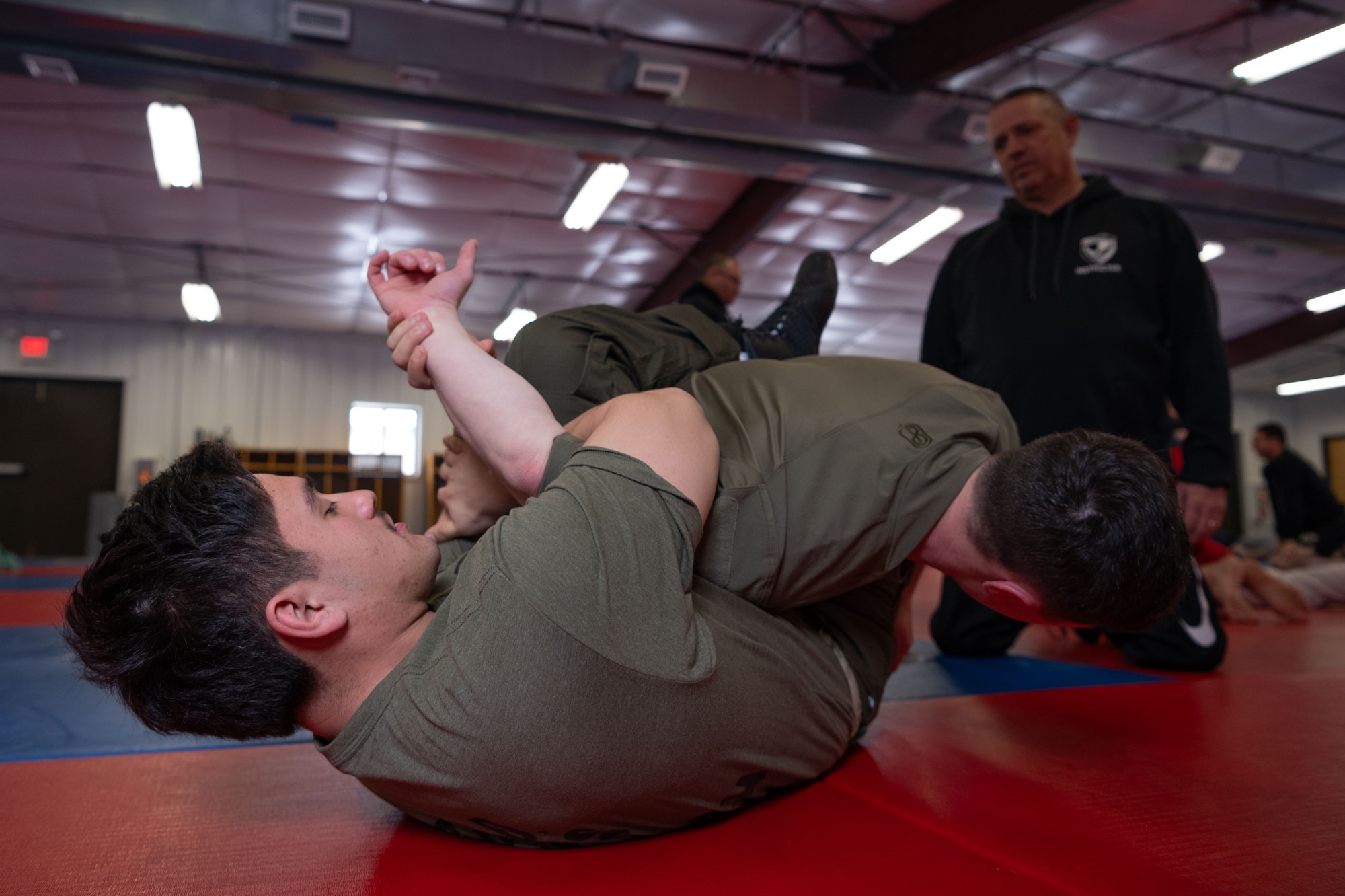 An 87th Security Forces Squadron member performs Brazilian Jiu Jitsu maneuvers during a training course at Joint Base McGuire-Dix-Lakehurst, N.J., Jan. 18, 2024. Master Carlos Machado, a Brazilian Jiu Jitsu instructor, crafted BJJ instruction to expand on the hand-to-hand combat skills crucial to the Security Forces mission, merging BJJ tactics with elements of mindfulness, physical readiness, as well as honing the craft. (U.S. Air Force photo by Staff Sgt. Monica Roybal)