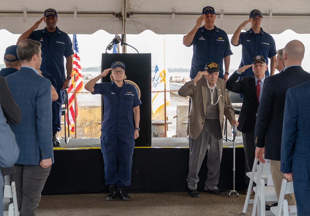 Adm. Linda L. Fagan, Commandant of the Coast Guard, and retired Senior Chief Petty Officer Thomas Gelwicks salute during a groundbreaking ceremony in North Charleston, South Carolina, Jan. 26, 2024.