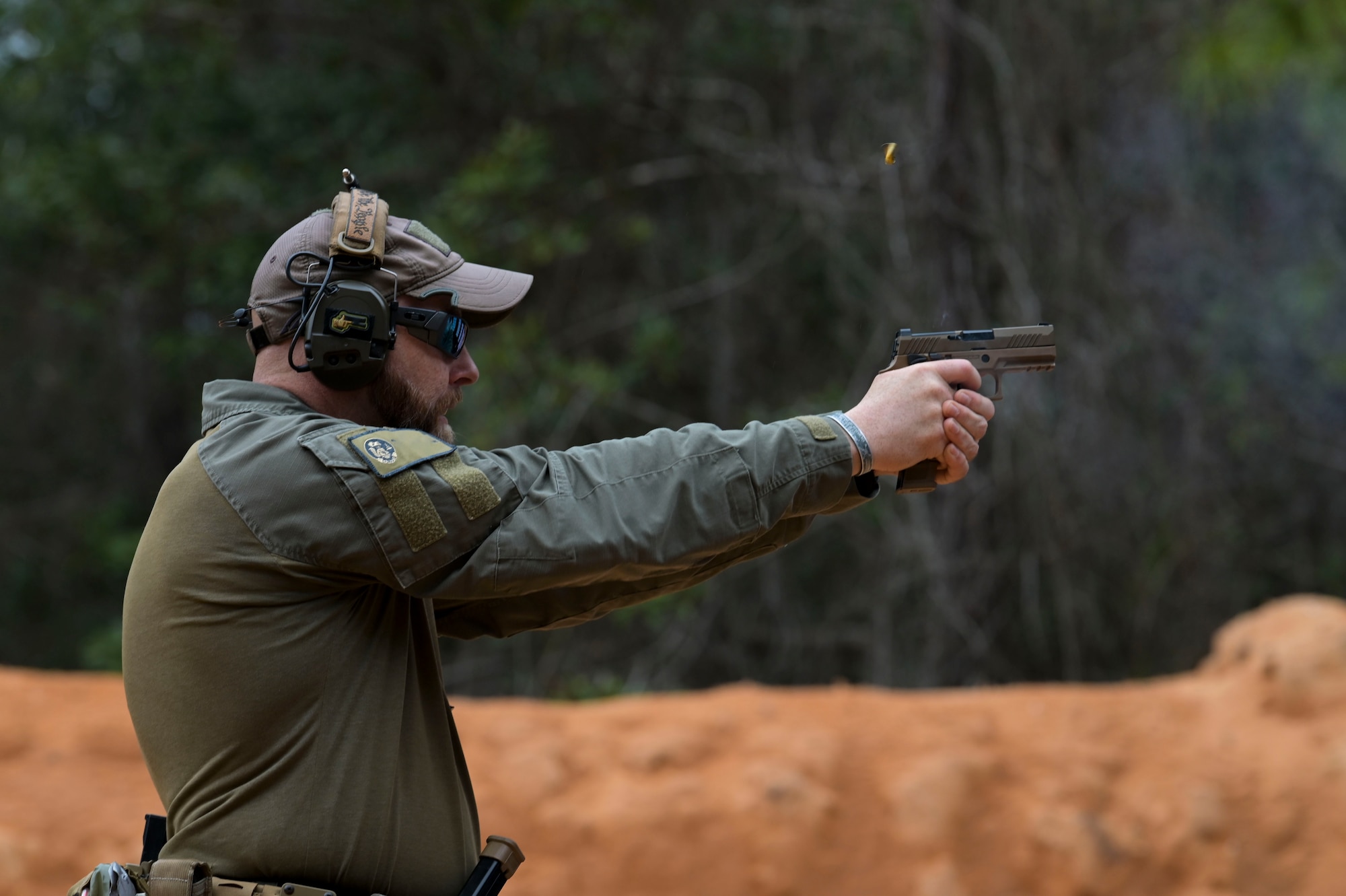 An Instructor with the 371st Special Operations Combat Training Squadron shoots a pistol.