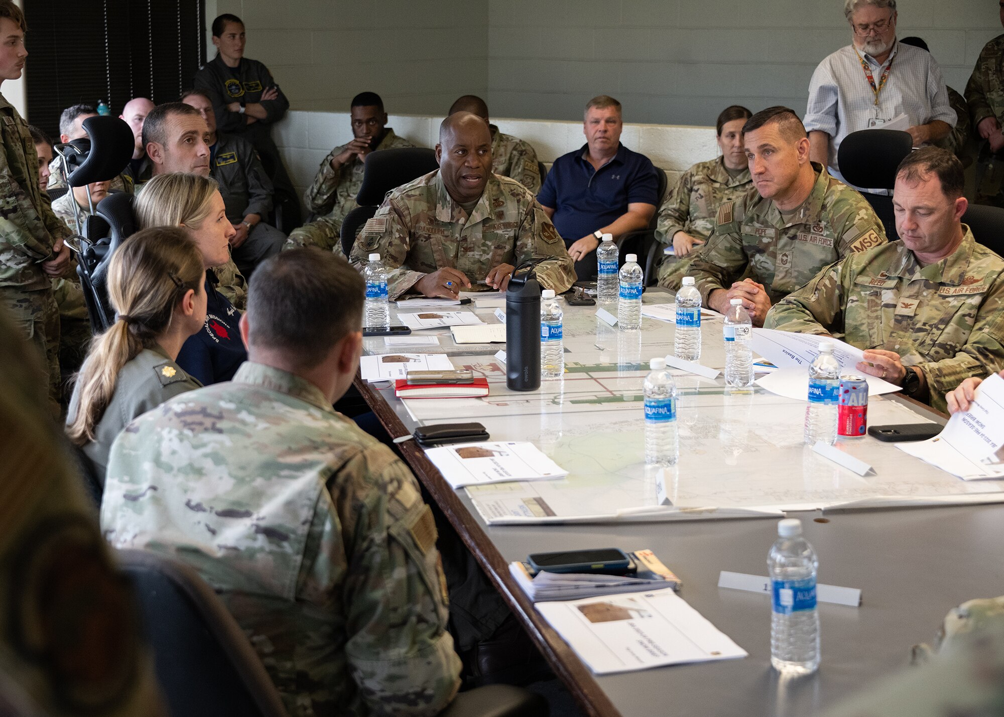 Group of people speak to each other at a table.