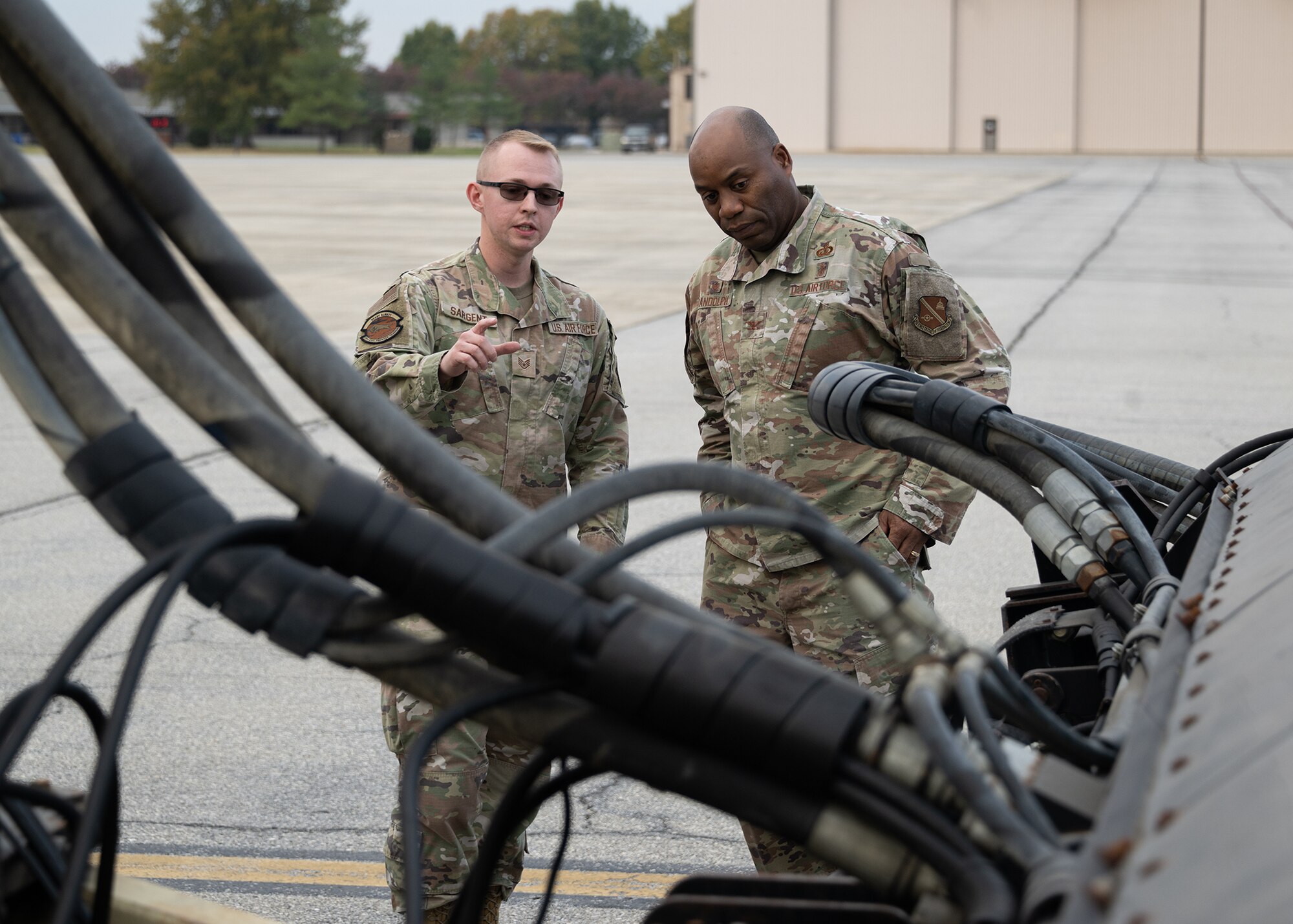 Two people speak and point at electrical wires.