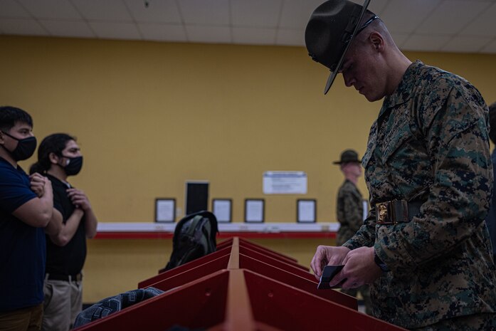 U.S. Marine Corps Sgt. Davis Wheat, a Murrieta, California native and drill instructor with Receiving Company, Support Battalion, searches for contraband as a part of the receiving process at Marine Corps Recruit Depot San Diego, Jan. 22, 2024. During the receiving process, recruits are searched for contraband, given a haircut, allowed a phone call home, and issued gear. (U.S. Marine Corps photo by Lance Cpl. Jacob B. Hutchinson)