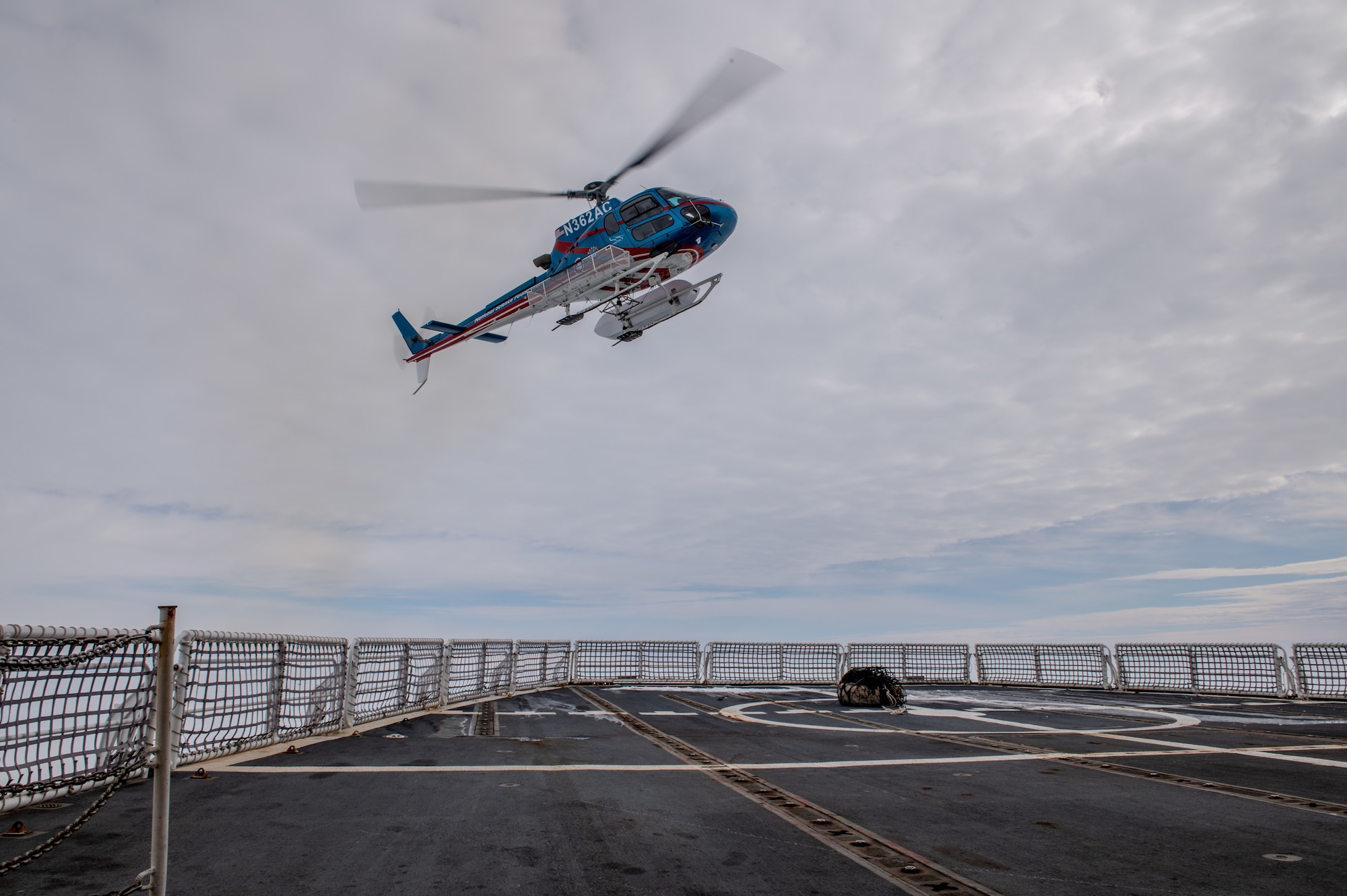 A National Science Foundation helicopter air crew departs from the U.S. Coast Guard Cutter Polar Star (WAGB 10) after dropping off parts to the cutter, Jan. 9, 2024. Polar Star is enroute to Antarctica in support of Operation Deep Freeze, a joint service, interagency support operation for the National Science Foundation, which manages the United States Antarctic Program. (U.S. Coast Guard photo by Petty Officer 2nd Class Ryan Graves)