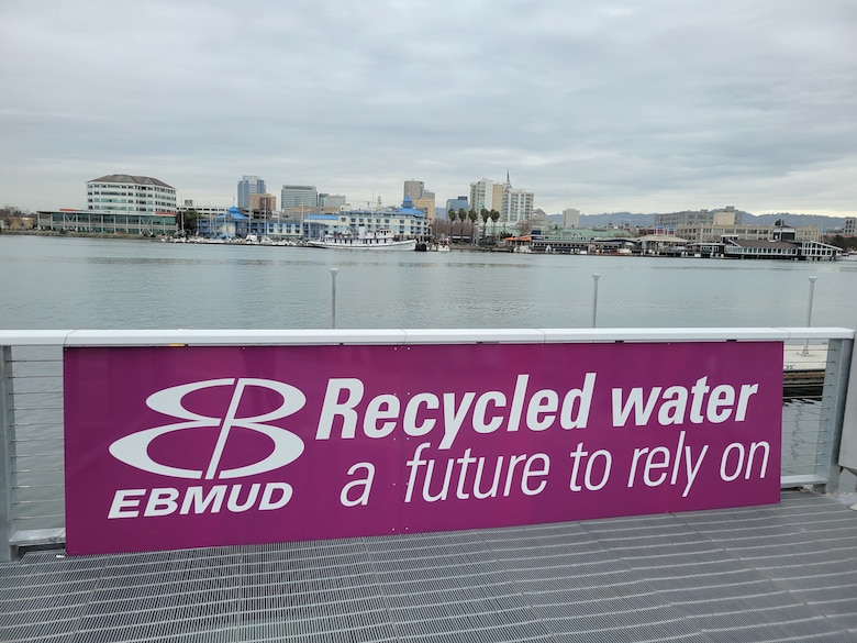 Pink sign with white letters saying recycled water, a future to rely on.