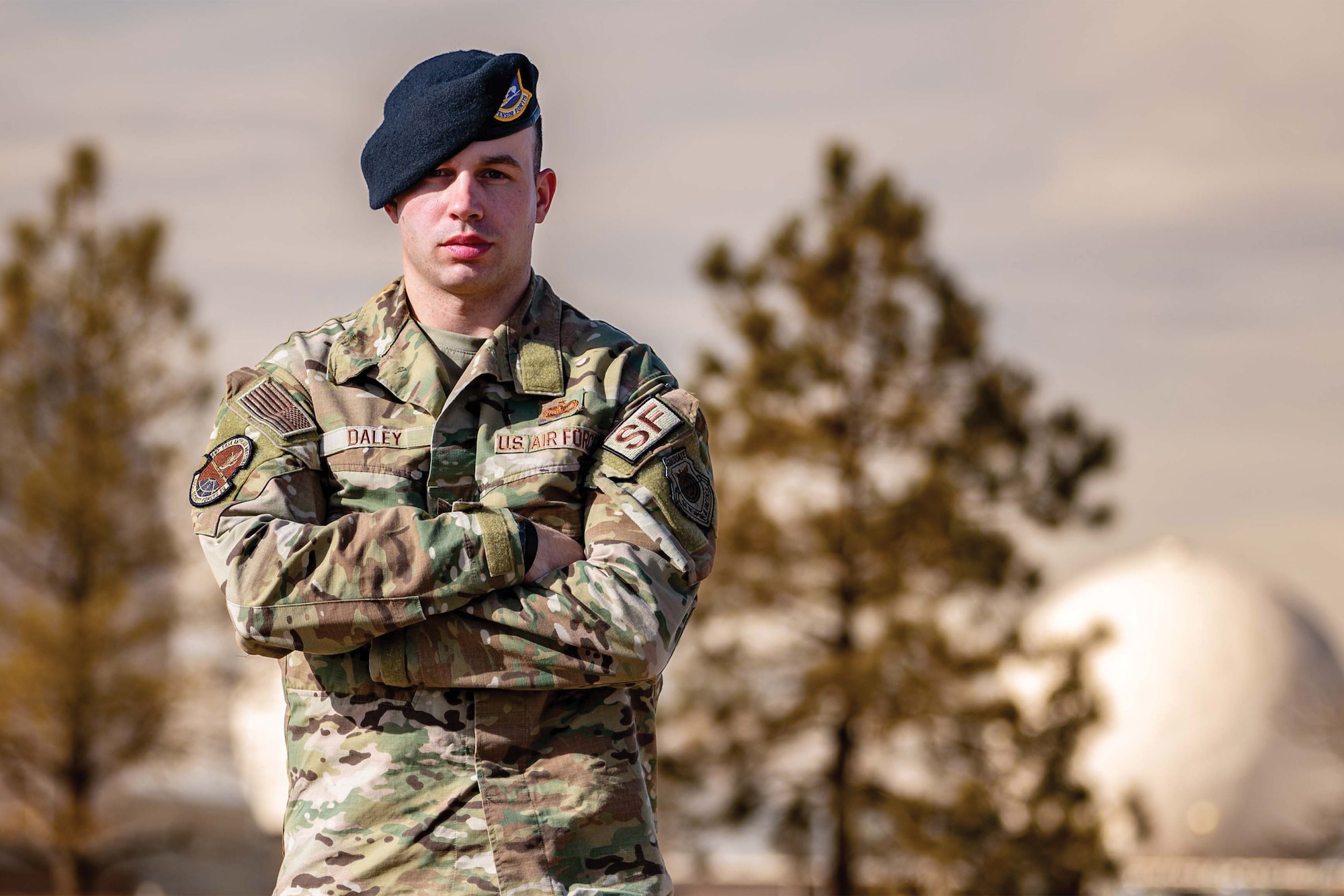 Man poses with arms crossed.