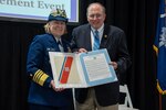 Adm. Linda Fagan, commandant of the Coast Guard, presents Charleston County Council Chairman Herbert Sass III with an official designation during a Coast Guard Community Designation Ceremony for Greater Charleston in Charleston, South Carolina, Jan. 26, 2024.