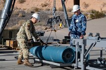 US and Royal Australian Air Force Airmen building GBU munitions.