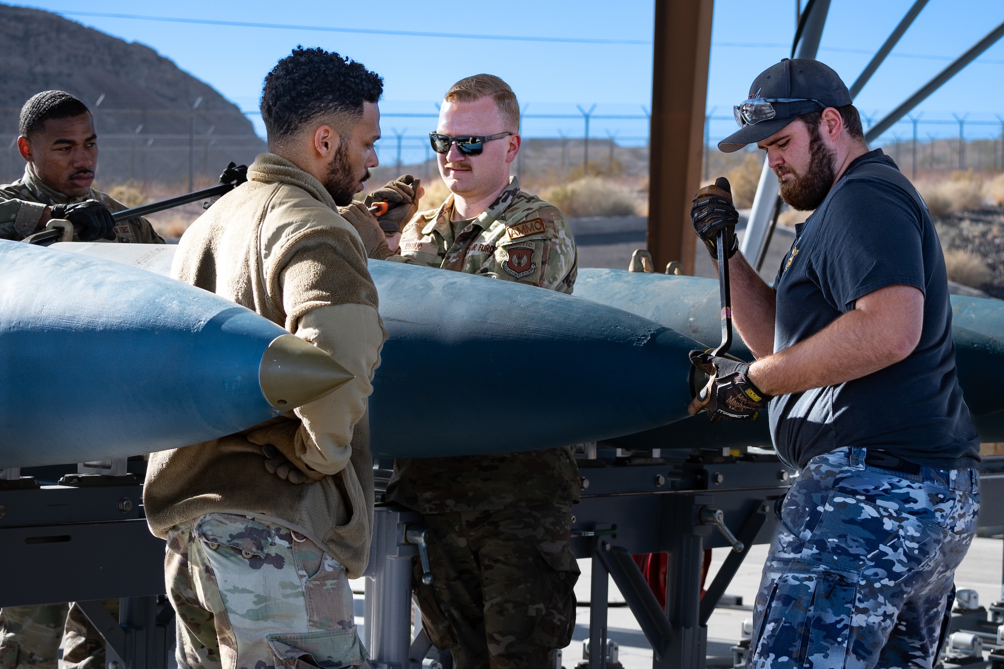 US and Royal Australian Air Force Airmen building GBU munitions.