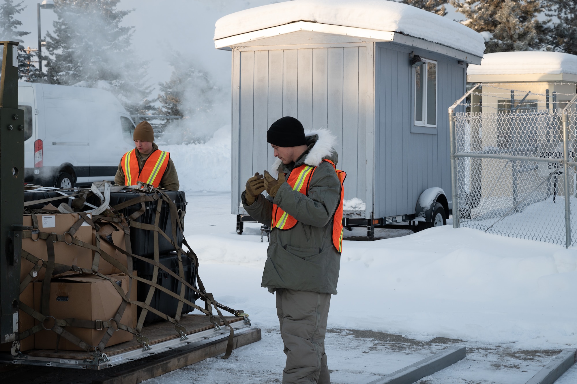Airmen from the 354th Logistics Readiness Squadron guide a forklift to unload equipment as a part of exercise Arctic Gold 24-1 on Eielson Air Force Base, Alaska, Jan. 24, 2024. Arctic Gold helped prepare airmen for real-life deployment as well as hone their skills within their career fields. (U.S. Air Force photo by Airman Spencer Hanson)