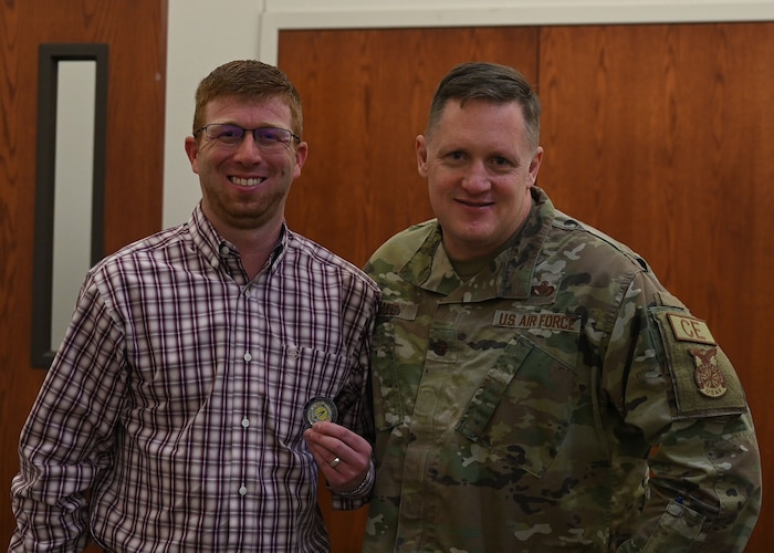 U.S. Air Force Brig. Gen. William Kale, Air Force Civil Engineer Center commander, coins Jarrett Louder, 17th Civil Engineering Squadron program manager, during his visit at the 17th CES building, Goodfellow Air Force Base, Texas, Jan. 18, 2024. Kale coined Louder for his dedication to the Natural Resource office. (U.S. Air Force photo by Airman 1st Class Evelyn D’Errico)