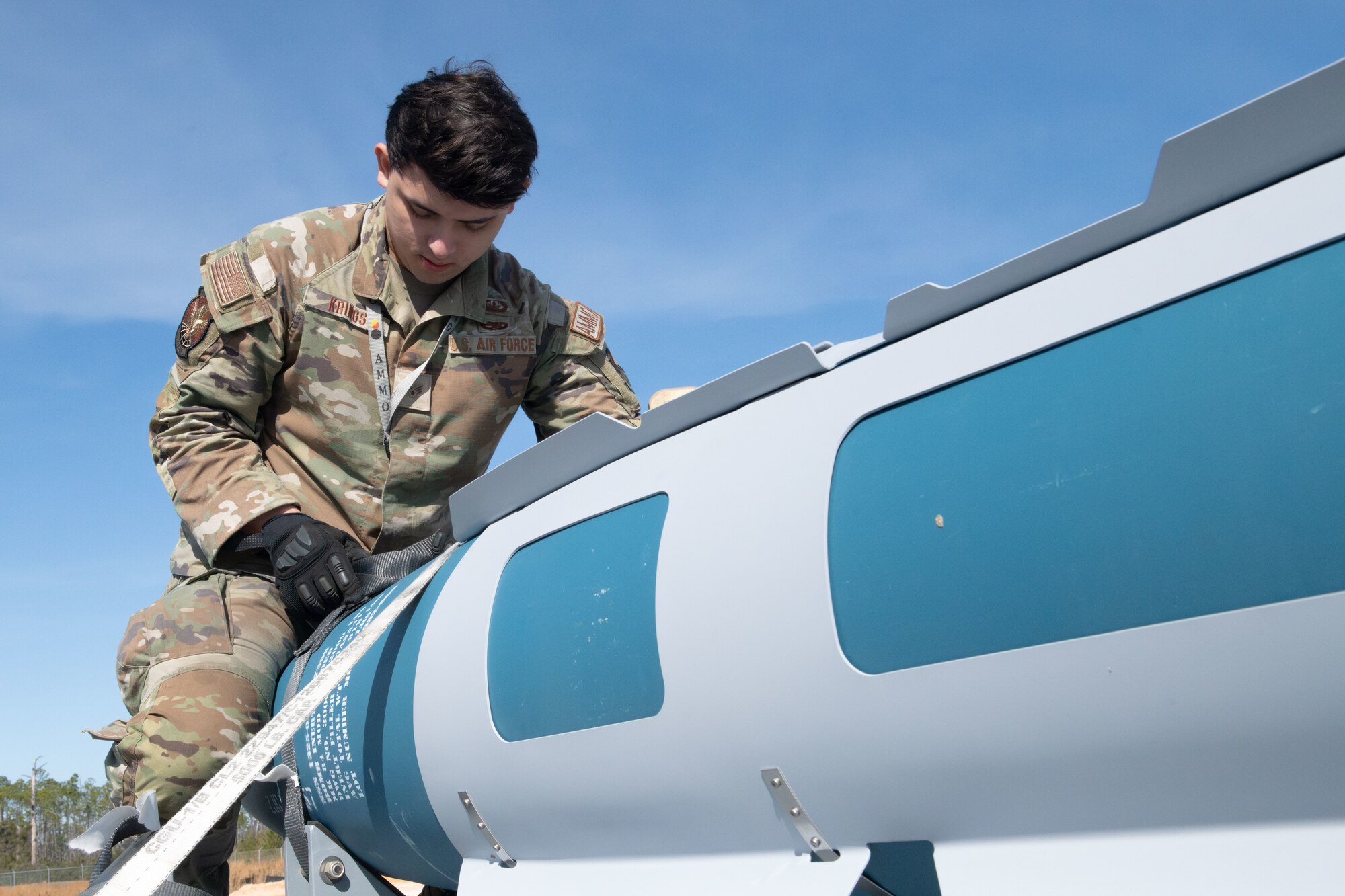 a man secures munitions to trailer