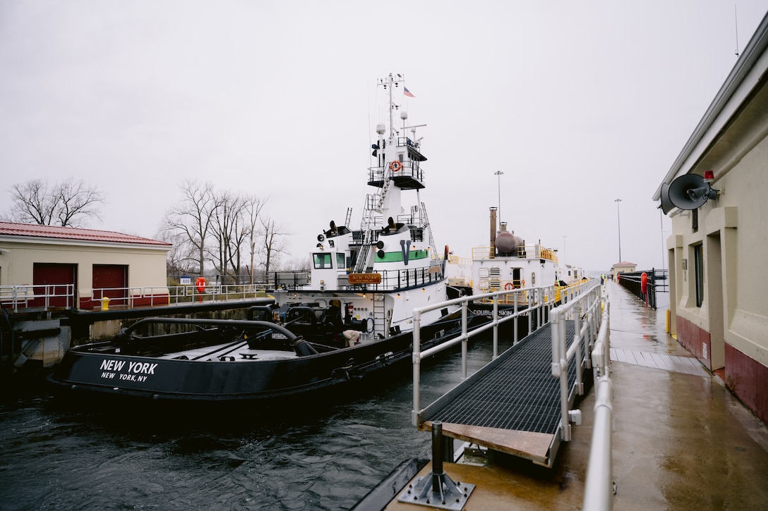A tugboat guides a vessel through the Black Rock Lock in Buffalo, New York.