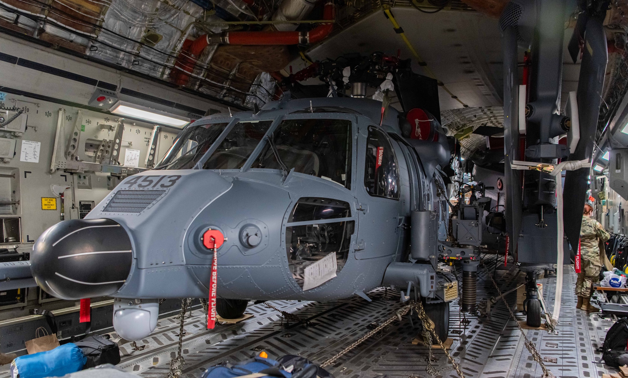 An HH-60W Jolly Green II sits inside of a C-17.