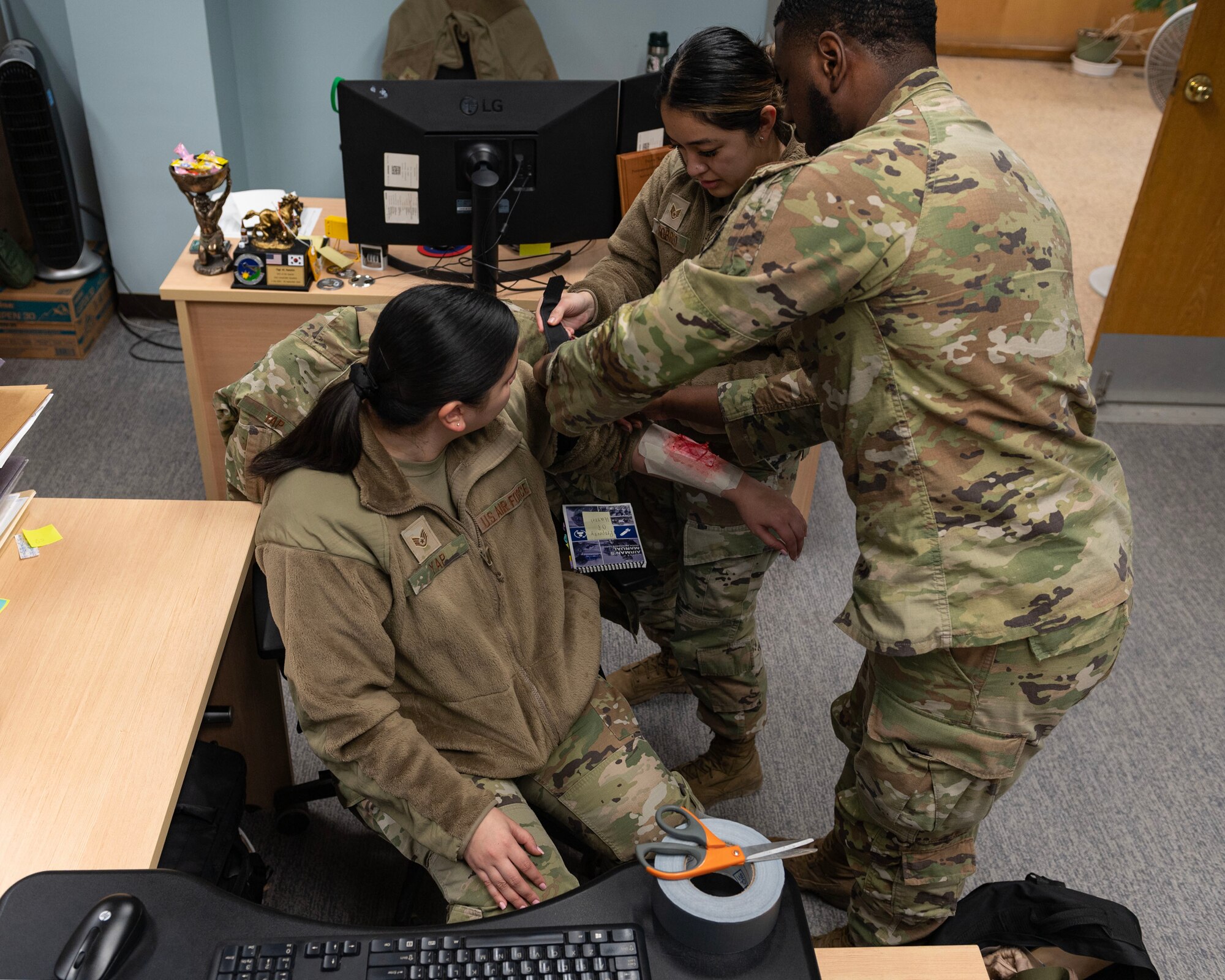 U.S. Air Force Senior Airman Maaliq Williams, 51st Comptroller Squadron finance customer service technician, left, and Staff Sgt. Riciel Sobreo, 51st CPTS resource advisor, conducts tactical combat casualty care on Staff Sgt. Angelica Yap, 51st CPTS financial operations supervisor, during Beverly Midnight 24-1 at Osan Air Base, Republic of Korea, Jan. 29, 2024. TCCC is the new standard across the Department of Defense for first response care. Since June 2022, the TCCC program has completely replaced Self-Aid Buddy Care, also known as SABC. (U.S. Air Force photo by Staff Sgt. Aubree Owens)