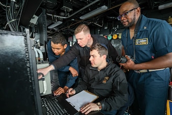 Sailors aboard USS John Finn (DDG 113) conduct intelligence gathering reports during routine operations in the South China Sea.
