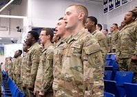 Soldiers standing at attention with mouths opening as they recite the Soldier's Creed