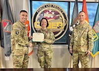 Commanding General Maj. Gen. Paul Stanton and Command Sgt. Maj. Michael Starrett present Deputy Commanding General Johanna Clyborne the Legion of Merit for her hard work and dedication during her tenure here.