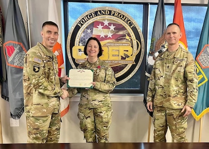 Commanding General Maj. Gen. Paul Stanton and Command Sgt. Maj. Michael Starrett present Deputy Commanding General Johanna Clyborne the Legion of Merit for her hard work and dedication during her tenure here.