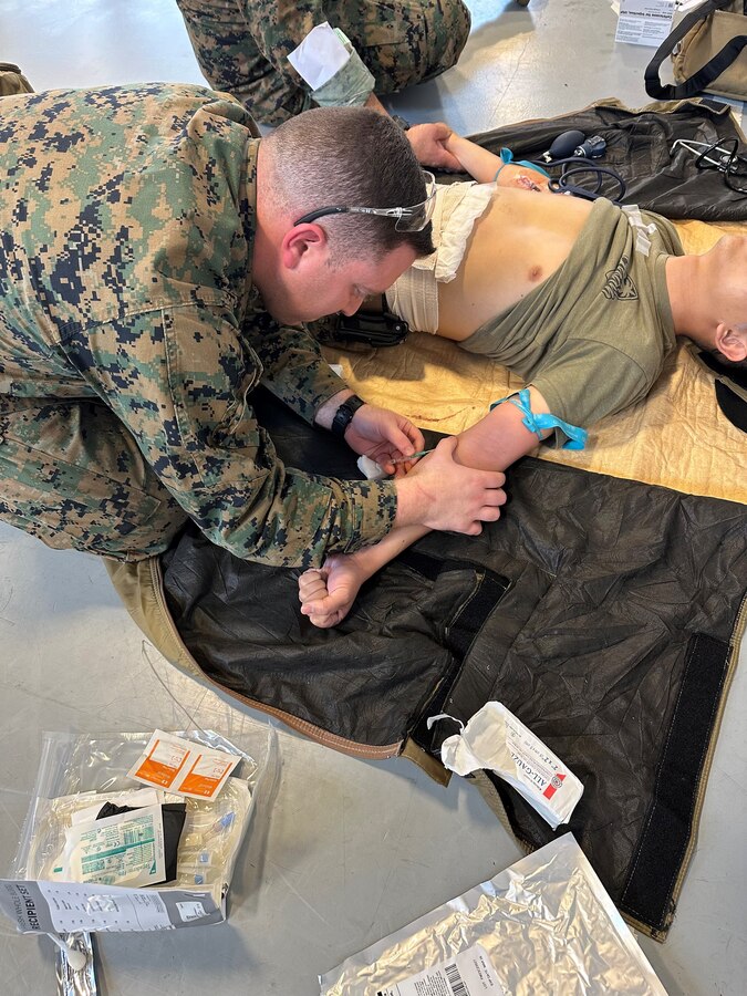 U.S. Navy Hospital Corpsman Chief Petty Officer Julio Calderin-Serrano, 23D Marine Regiment, 4th Marine Division, Marine Forces Reserve, gains IV access to his patient, Sgt. Timothy Pham, before beginning blood transfusion for the Valkyrie program in San Bruno, CA on Jan. 10, 2024. The Valkyrie Program is a course designed to teach attendees how and when to apply a whole blood transfusion to casualties in a combat environment. (Courtesy Photo)